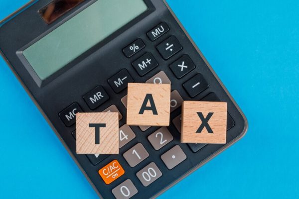 tax-planning-concept-with-wooden-cubes-calculator-blue-table-flat-lay_176474-9519